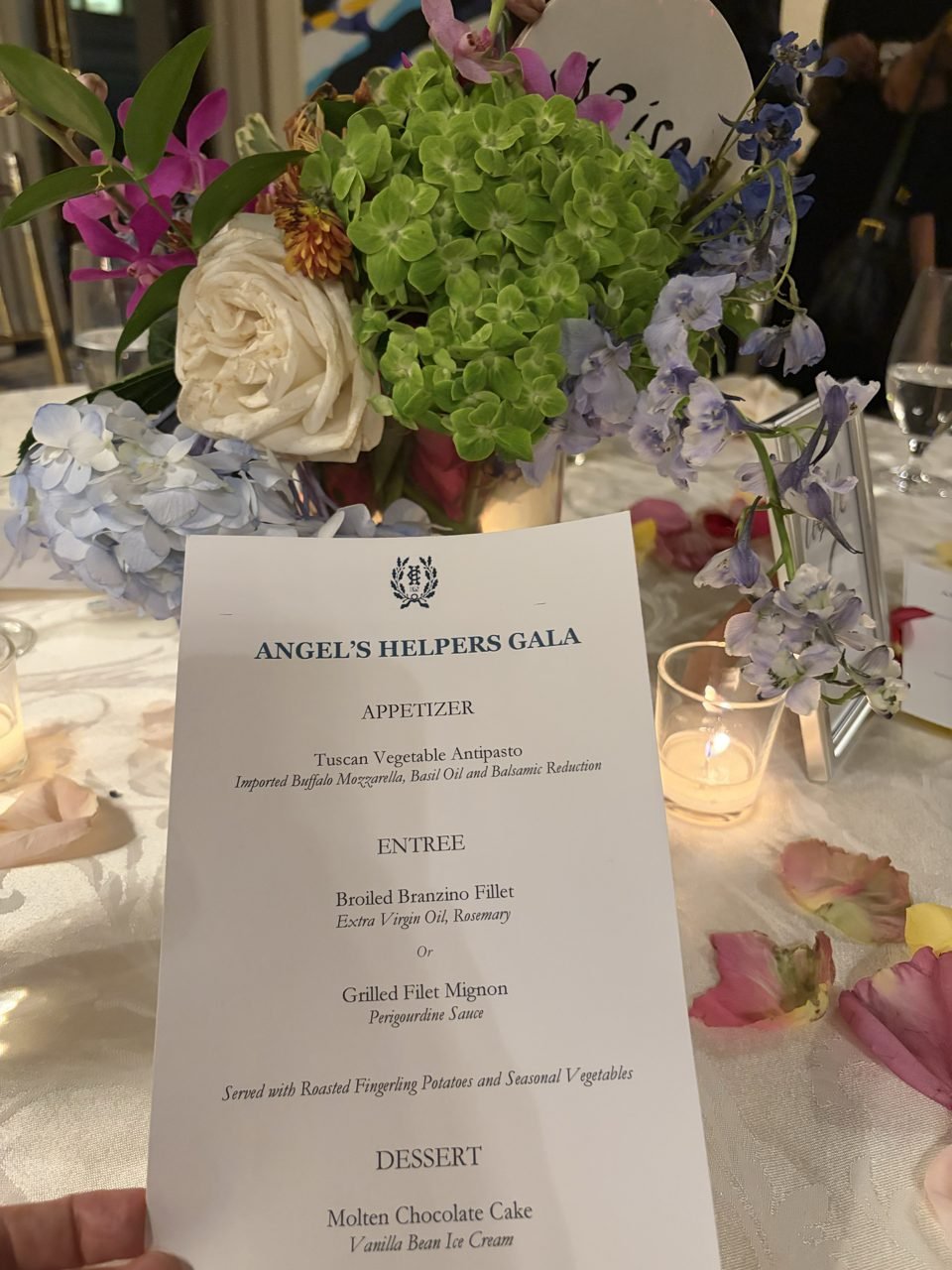 Flowers, candles and the printed Angel’s Helpers Gala menu at the table.