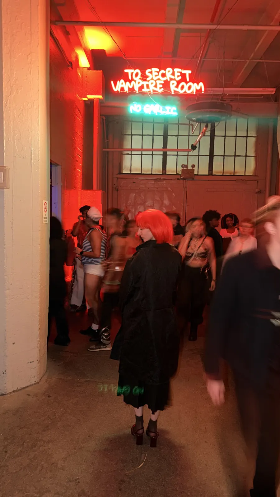Costumes and red light in a passage between the party spaces.