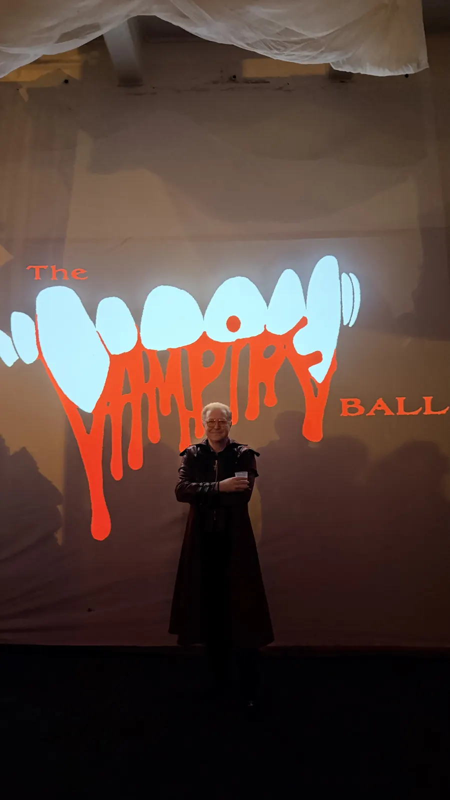 Costume portrait against the event’s projected lettering.